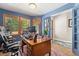 Comfortable home office with wooden desk, bright natural light and colorful area rug at 9117 Nambe Trl, Lone Tree, CO 80124