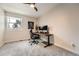 Bedroom with a ceiling fan featuring a wooden desk, modern chair, and a large window at 6443 S Florence Way, Englewood, CO 80111