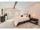 Bright bedroom featuring neutral colors, a beamed vaulted ceiling, and a large window at 6443 S Florence Way, Englewood, CO 80111