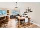 Dining room featuring wood floors, large windows, modern lighting, and direct access to kitchen at 6443 S Florence Way, Englewood, CO 80111