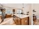 Bright kitchen featuring wood floors, wood cabinets, stainless steel appliances, and a large island at 6443 S Florence Way, Englewood, CO 80111