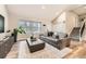 Bright living room with wood floors, modern decor, a large window, and staircase to the second floor at 6443 S Florence Way, Englewood, CO 80111