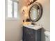 Cozy half-bathroom featuring a classic vanity, lighting fixture and decorative round mirror at 285 N Holcomb St, Castle Rock, CO 80104