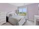 Bedroom with a large window view, soft lavender colored walls, white dresser, and plush bedding at 3048 Deer Creek Ranch Loop, Parker, CO 80138