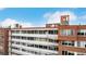 Eye-level shot of brick building showing many windows and a balcony, against a blue sky at 1196 N Grant St # 705, Denver, CO 80203