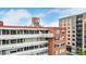 Exterior angle view of the brick building shows white balcony, other apartments, and blue sky at 1196 N Grant St # 705, Denver, CO 80203