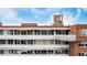 View of multi-story brick building with white accents and a white balcony under a blue sky at 1196 N Grant St # 705, Denver, CO 80203