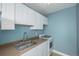 Compact kitchen features white cabinets, a stainless steel sink, and a gas range, perfect for efficient cooking at 1196 N Grant St # 705, Denver, CO 80203