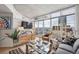 Bright living room features floor-to-ceiling windows with city views, hardwood floors, and modern furnishings at 891 14Th St # 2703, Denver, CO 80202