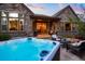 Stone house featuring a hot tub, a patio with outdoor furniture, and a fire pit at 6840 Northstar Cir, Castle Rock, CO 80108