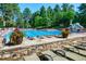 The refreshing community pool is lined with lounge chairs, surrounded by mature trees for added privacy at 6840 Northstar Cir, Castle Rock, CO 80108