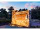 The stone entrance to Northstar community is beautifully illuminated at dusk, surrounded by lush greenery at 6840 Northstar Cir, Castle Rock, CO 80108