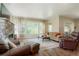 Cozy living room with a stone fireplace, large windows, and comfortable seating at 6840 Northstar Cir, Castle Rock, CO 80108