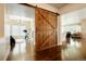 Elegant home entrance featuring wood floors and a rustic sliding barn door at 6840 Northstar Cir, Castle Rock, CO 80108