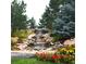 Relaxing water feature with natural stone, colorful flowers, and lush landscaping for a tranquil setting at 6840 Northstar Cir, Castle Rock, CO 80108
