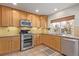 Kitchen boasts wood cabinets, granite countertops, and stainless steel appliances at 4460 S Himalaya Ct, Aurora, CO 80015