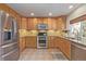 Kitchen with wood cabinets, granite countertops, and stainless steel appliances at 4460 S Himalaya Ct, Aurora, CO 80015