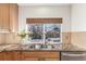 Kitchen sink with granite countertop and view of backyard through window at 4460 S Himalaya Ct, Aurora, CO 80015