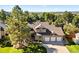Charming two-story brick home with a well-manicured lawn, mature trees, and a three-car garage at 5344 E Otero Dr, Centennial, CO 80122