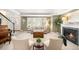 Bright living room featuring a fireplace, large windows, and a glimpse of the front entrance at 5344 E Otero Dr, Centennial, CO 80122