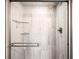 Modern shower featuring glass door, gray tile surround and built in shelving at 5344 E Otero Dr, Centennial, CO 80122