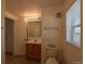 Bright bathroom featuring a wooden vanity, a well-lit mirror, and tiled floors at 635 2Nd St, Bennett, CO 80102