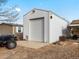 Detached garage with a large overhead door at 635 2Nd St, Bennett, CO 80102