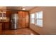 This kitchen features wooden cabinets, a stainless-steel refrigerator, and hardwood flooring at 635 2Nd St, Bennett, CO 80102