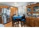 Eat-in kitchen with wood cabinets, stainless refrigerator, and dining area with blue tablecloth at 635 2Nd St, Bennett, CO 80102