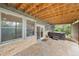 Covered back patio area showcasing stone flooring, outdoor hot tub, and access to the backyard at 1122 Forest Trails Dr, Castle Pines, CO 80108
