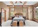 Charming bedroom features wooden beams, a cozy bed, and large windows providing lots of natural light at 1122 Forest Trails Dr, Castle Pines, CO 80108