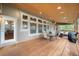 Inviting covered deck with wood floors, seating, and large windows, perfect for outdoor entertaining at 1122 Forest Trails Dr, Castle Pines, CO 80108