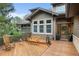Charming outdoor deck featuring a seating area with a wooden bench and rocking chairs to enjoy wooded views at 1122 Forest Trails Dr, Castle Pines, CO 80108