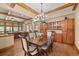 Open concept dining room boasts hardwood floors, wood beam ceiling and custom-built cabinetry at 1122 Forest Trails Dr, Castle Pines, CO 80108