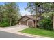 Traditional two-story home with a three-car garage and well-manicured front lawn nestled among mature trees at 1122 Forest Trails Dr, Castle Pines, CO 80108