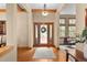 Inviting foyer featuring hardwood flooring, decorative beams, and view into an open floor plan at 1122 Forest Trails Dr, Castle Pines, CO 80108