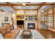 Inviting living room with hardwood floors, built-in shelving, stone fireplace, and wood beam accents at 1122 Forest Trails Dr, Castle Pines, CO 80108