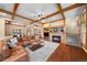 Cozy living room showcasing hardwood floors, a stone fireplace, and decorative wood beams with open concept design at 1122 Forest Trails Dr, Castle Pines, CO 80108