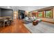 Open concept living room with bar area, wood floors, comfortable seating and bright light from windows at 1122 Forest Trails Dr, Castle Pines, CO 80108