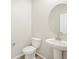 Clean bathroom with pedestal sink and round mirror at 1925 S Coolidge Way, Aurora, CO 80018