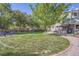 Expansive backyard featuring a lush lawn, patio area with outdoor furniture, and mature trees at 6857 S Franklin Cir, Centennial, CO 80122