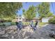 Inviting backyard featuring an outdoor fire pit with seating, lush lawn, and mature trees at 6857 S Franklin Cir, Centennial, CO 80122