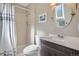 Well-maintained bathroom featuring a shower, toilet, wooden vanity and round mirror at 6857 S Franklin Cir, Centennial, CO 80122