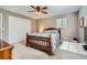 Well-lit bedroom featuring a wooden bed frame, white dresser, ceiling fan and neutral-toned walls at 6857 S Franklin Cir, Centennial, CO 80122