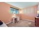 Bedroom with light orange walls, carpeted floor, large window, white desk, and closet at 6857 S Franklin Cir, Centennial, CO 80122