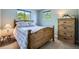 Bedroom with a wooden bed frame, matching dresser, and views of the outdoors through the windows at 6857 S Franklin Cir, Centennial, CO 80122