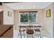 Bright dining area featuring a wooden table, white chairs, and a large window overlooking a green backyard at 6857 S Franklin Cir, Centennial, CO 80122