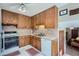 Efficient kitchen with wood cabinets, classic appliances, and a bright ceiling fan with lights at 6857 S Franklin Cir, Centennial, CO 80122
