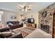 Cozy living room featuring a stone fireplace, plush leather sofas, patterned rug and ceiling fan at 6857 S Franklin Cir, Centennial, CO 80122