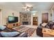 Comfortable living room featuring a stone fireplace, plush leather sofas, patterned rug and ceiling fan at 6857 S Franklin Cir, Centennial, CO 80122